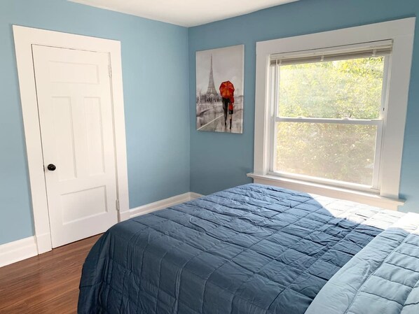 A bedroom with a bed, a window, and a door. - Newly Renovated Spacious 4BR peaceful downtown Apt (Montclair)