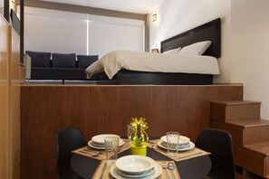 Enjoy a compact room with a dining area, comfortable bed, and balcony view.
