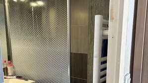 A bathroom with a glass shower enclosure, a white sink, and a towel rack. - Maison au Calme à Proximité du lac (Hourtin)