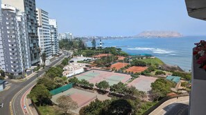 Une vue sur la côte, avec des courts de tennis, une route et des immeubles de grande hauteur.