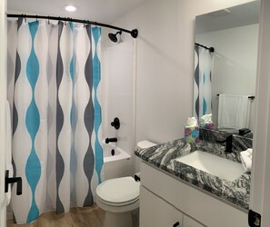 Tina con regadera, secadora de cabello, toallas, jabón 