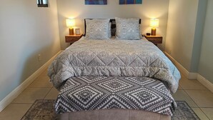 A bedroom with a bed, two bedside tables, a nightstand, a bench, and two wall-mounted paintings. - Queen. Minutes to Wilton drive. Private entrance and bathroom (Wilton Manors)