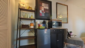A compact kitchenette with a refrigerator, microwave, and shelves with various kitchen items. - Queen. Minutes to Wilton drive. Private entrance and bathroom (Wilton Manors)