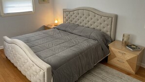 A bedroom with a bed, nightstand, and dresser. - Visit Monticello, Wineries, UVA:  Room for a Crowd (Troy)