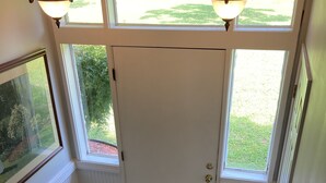 A staircase with white balusters and a wooden handrail leading to a door with a glass panel. - Visit Monticello, Wineries, UVA:  Room for a Crowd (Troy)