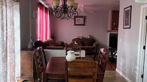 A dining area with a table and chairs, a chandelier, and a sofa in the background. - 3 bedroom house 5 minutes away from the airport in Colorado Springs all for you. (Colorado Springs)