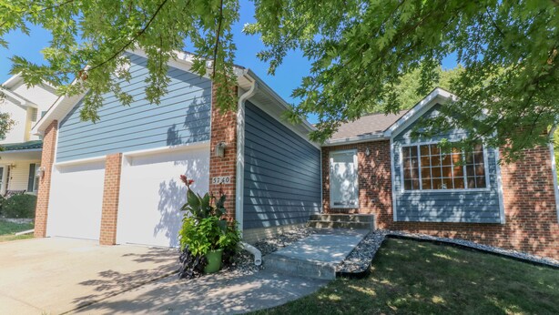 A residential house with a garage, brick exterior, and a front yard with a small garden and steps leading to the entrance. - 5 Bedroom Lincoln Home 10 Minutes from Downtown (Lincoln)