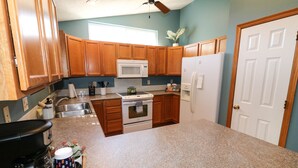 A kitchen with wooden cabinets, a microwave, a stove, and a refrigerator. - 5 Bedroom Lincoln Home 10 Minutes from Downtown (Lincoln)