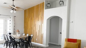 Un comedor con pared de madera, ventilador de techo y sofá.