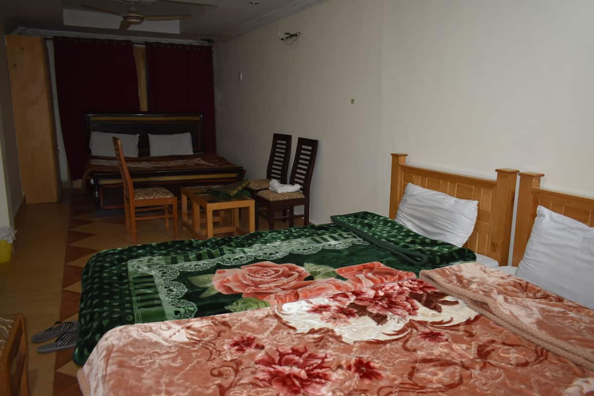 Une chambre à coucher avec un lit, une chaise, un bureau et une armoire.