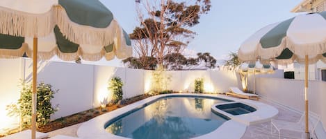 Una piscina al aire libre, sillones reclinables de piscina