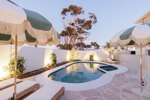 Alberca al aire libre y camastros 