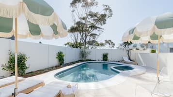 Una piscina al aire libre, tumbonas