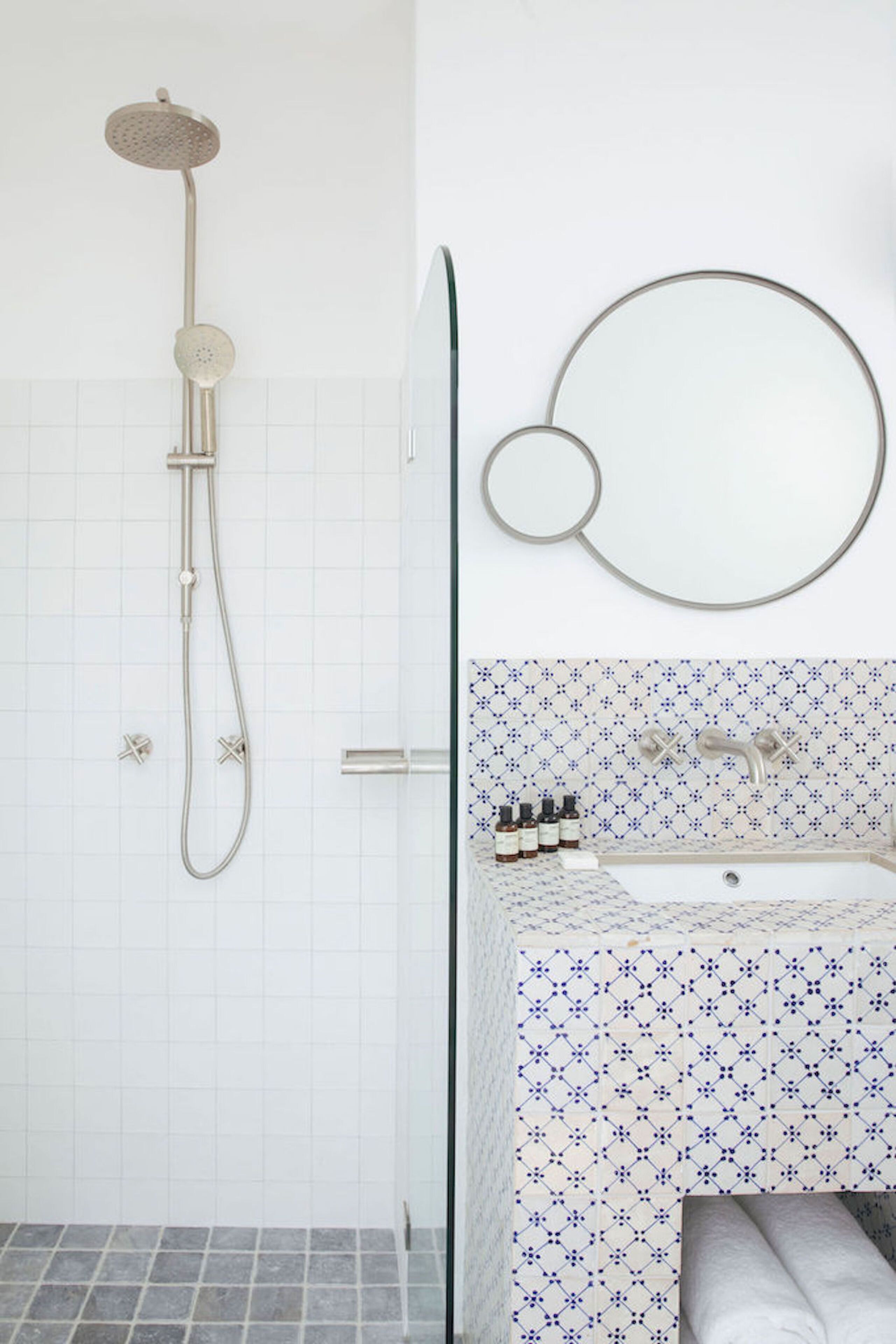 A bathroom with a shower, a sink, and a mirror.