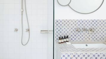 A bathroom with a shower, a sink, and a mirror.