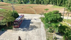 A bus parked on a concrete surface with a mountainous landscape in the background. - Khach san So Oanh  (Dam Thuy)