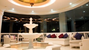 A spacious lobby with a central fountain, elegant seating, and a grand chandelier. - Estancia Resort Hotel (Tagaytay)