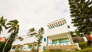 A modern two-story building with a flat roof, large windows, and a balcony. - Estancia Resort Hotel (Tagaytay)