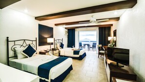 A hotel room with two beds, a TV, a desk, and a view of the sea. - Estancia Resort Hotel (Tagaytay)
