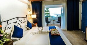 A hotel room with a bed, a tray with breakfast items, a balcony with a table and chairs, and a view of the sea. - Estancia Resort Hotel (Tagaytay)