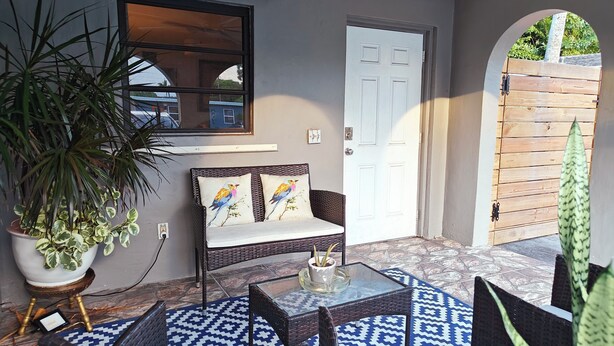 A room with a sofa, two chairs, a small table, and a potted plant. - King. Minutes to Wilton Drive. Private entrance and bathroom. (Wilton Manors)