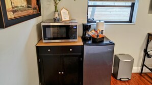 A compact kitchenette with a microwave, coffee maker, and a small refrigerator. - King. Minutes to Wilton Drive. Private entrance and bathroom. (Wilton Manors)