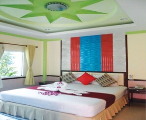 Quarto de hotel com cama, mesa de cabeceira, telefone e janela com cortinas.