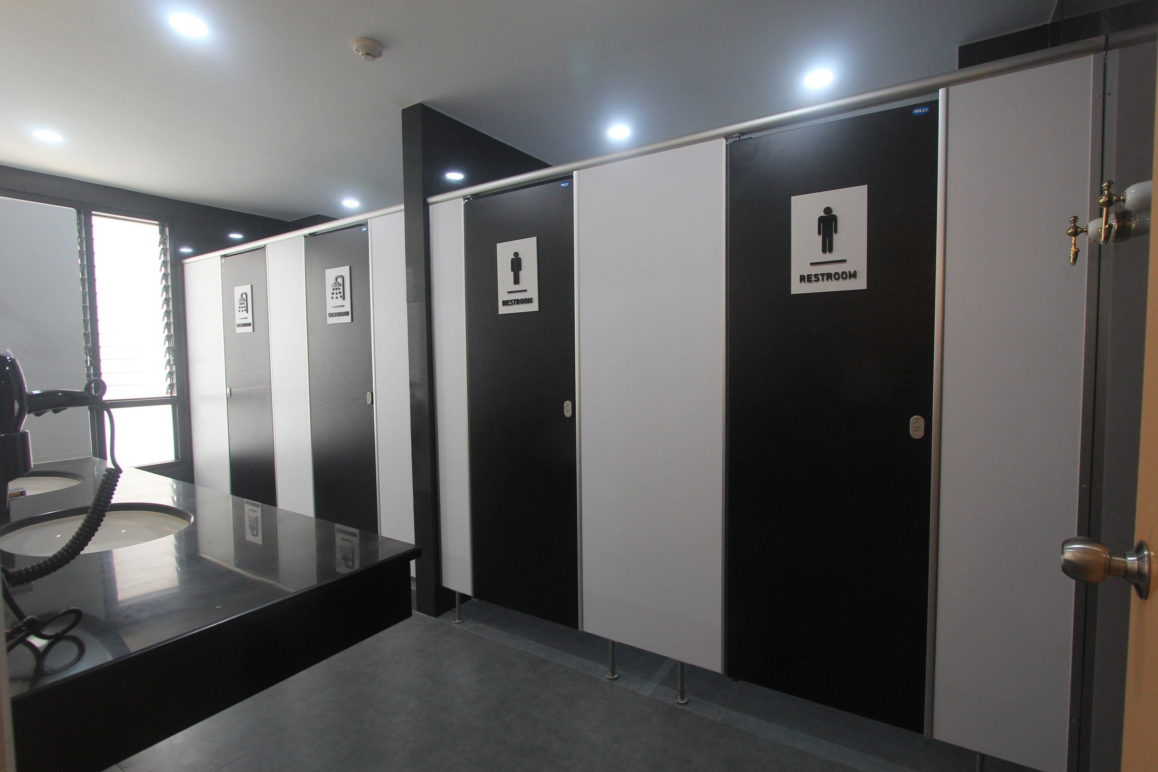 A restroom area with multiple stalls, each marked with a restroom sign.