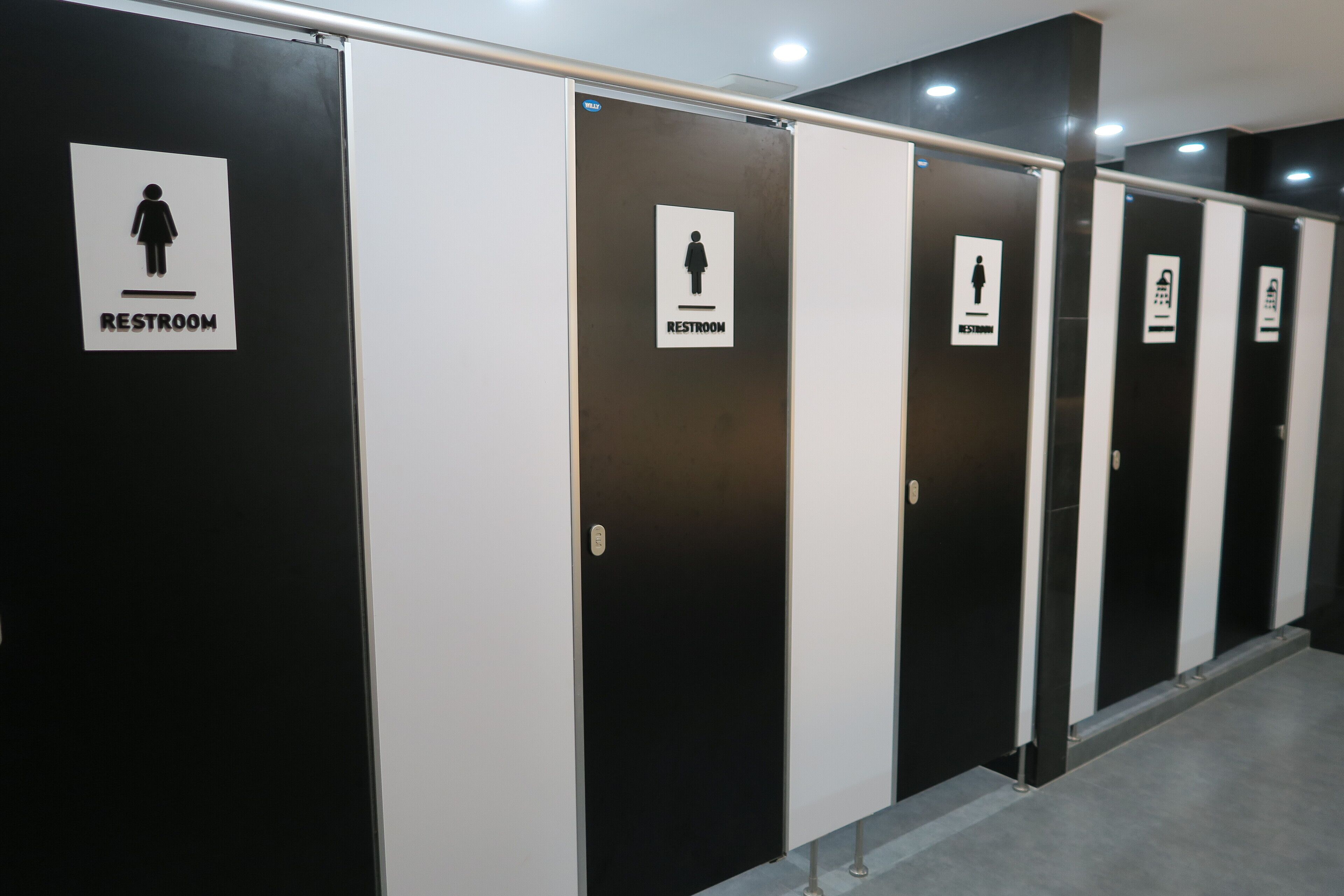A row of restroom doors with signs indicating gender-specific restrooms.