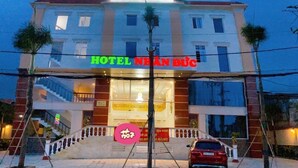 Un hotel con un letrero grande que dice "HOTEL NHAHN DUČ" y un letrero "CAN HO" encima.