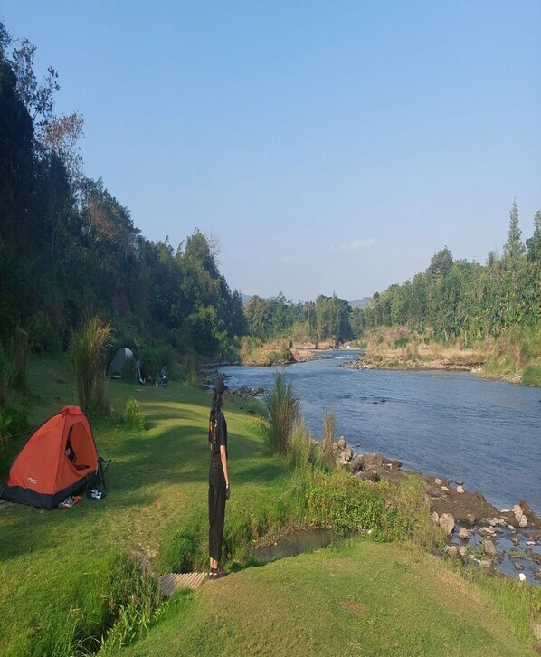 A campsite with tents and a river. - Potrobayan River Camp (Pundong)