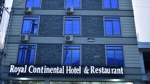 Exterior do Hotel & Restaurante Royal Continental, com várias janelas e unidades de ar condicionado.