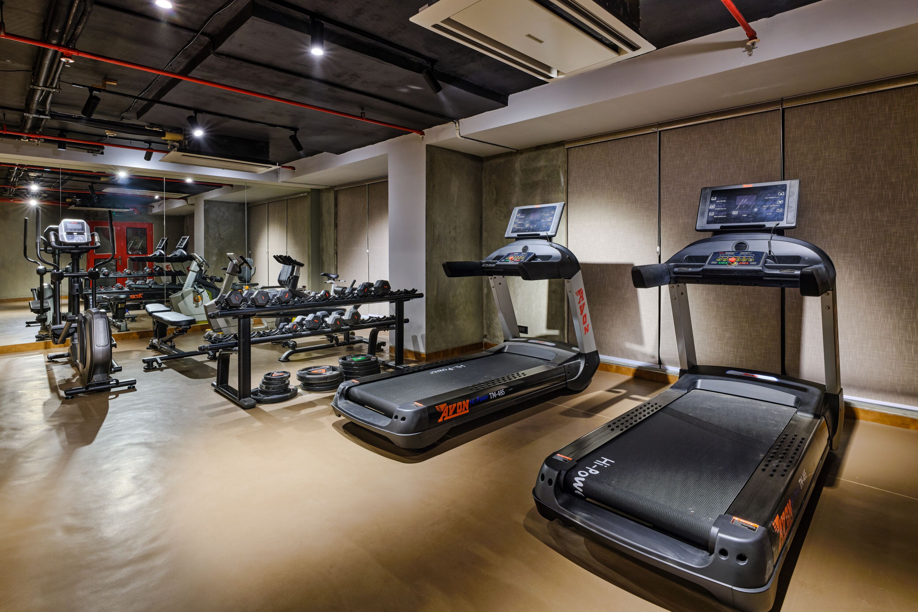 A gym with treadmills, weight machines, and free weights.