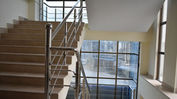 Una escalera con barandales de metal que sube a un piso superior.