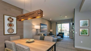 A modern living room with a wooden dining table, sofas, and a large window. - Westin Kierland Resort 2 Bedroom King Villa in Scottsdale-Sleeps 8 (Scottsdale)
