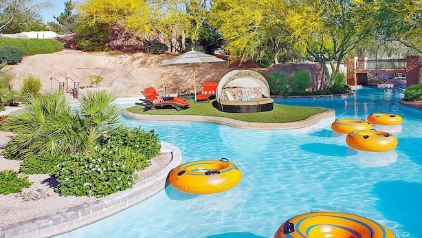 A swimming pool with multiple yellow inflatable tubes, a lounge area with red chairs, and a small garden with various plants. - Westin Kierland Resort 2 Bedroom King Villa in Scottsdale-Sleeps 8 (Scottsdale)