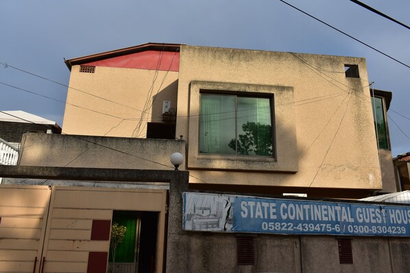 A building with a sign for "State Continental Guest House" including contact numbers. - State Continental Guest House (Mekhtar)