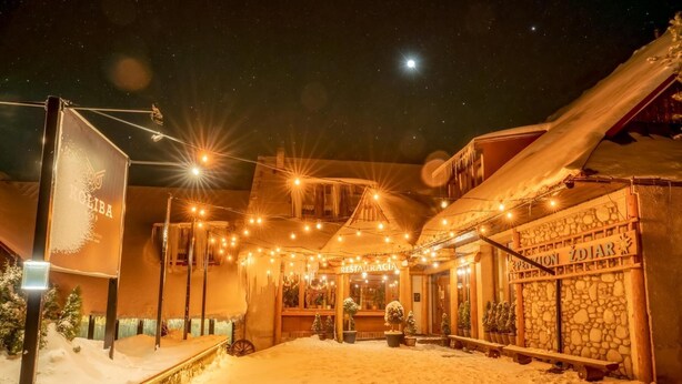 A snow-covered outdoor area with a restaurant named "RESTAURACIA" and a sign for "KOLIBA". - Hotel Sova Ždiar (Zdiar)