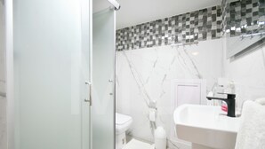 A modern bathroom with a glass shower enclosure, a white sink, and a toilet. - Villa Maya overlooking the bay, Jacuzzi, jetted bathtubs, pool table (Trou d'Eau Douce)