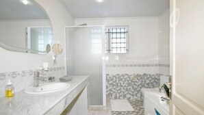 A bathroom with a marble vanity, a large mirror, a shower, and a bathtub. - Villa Maya overlooking the bay, Jacuzzi, jetted bathtubs, pool table (Trou d'Eau Douce)