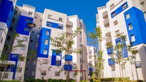 A modern apartment building with balconies, a clear sky, and a street lamp. - New And Furnished Apartment 5 Min From Beach On Foot (Agadir)