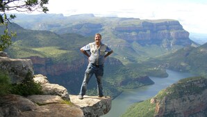 A person standing on a rock ledge overlooking a canyon with a river. - 3 bed Bush-tent Under 3 Trees, for Couple Plus Chaperone Free Lionhyena Sounds (Hoedspruit)