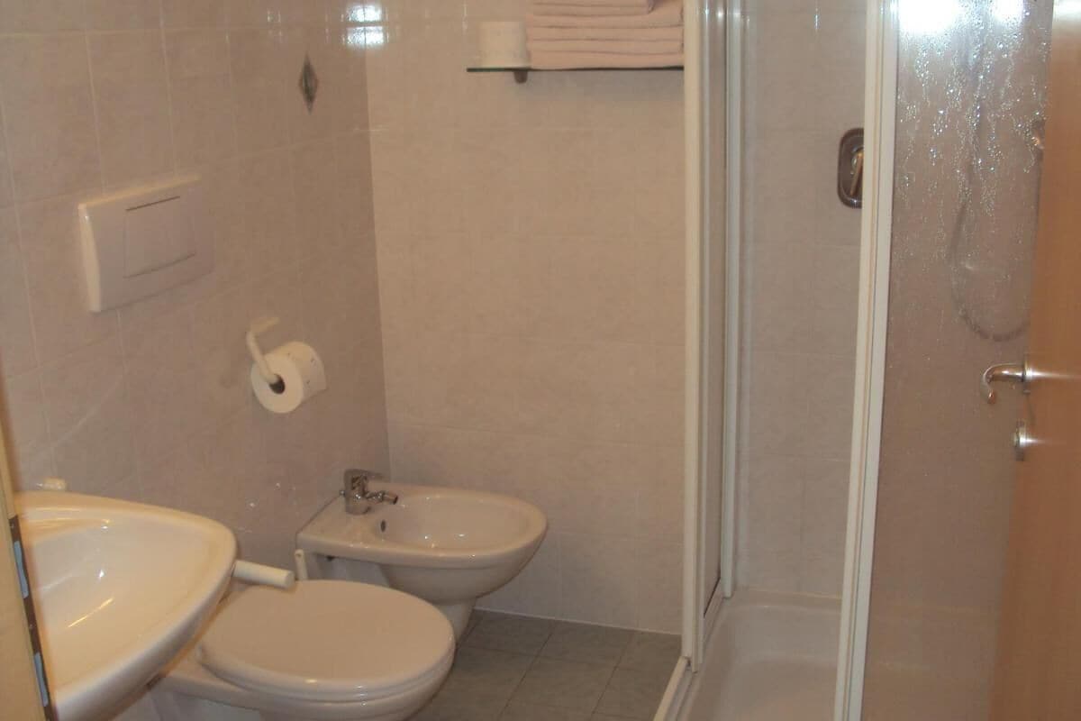 A bathroom with a toilet, bidet, and sink.