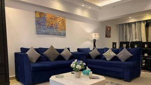 A modern living room with two blue sofas, a white coffee table, and decorative pillows. - Casa De Horyea , (Cairo)