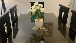 A dining table with a floral centerpiece, a painting on the wall, and a lamp. - Casa De Horyea , (Cairo)