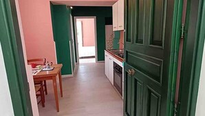 A narrow hallway with a dining area on one side and a kitchen on the other. - A Refuge Between Green And Blue (Tramonti)