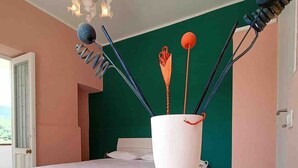 A bedroom with a bed, a white table, and a vase with decorative items. - A Refuge Between Green And Blue (Tramonti)
