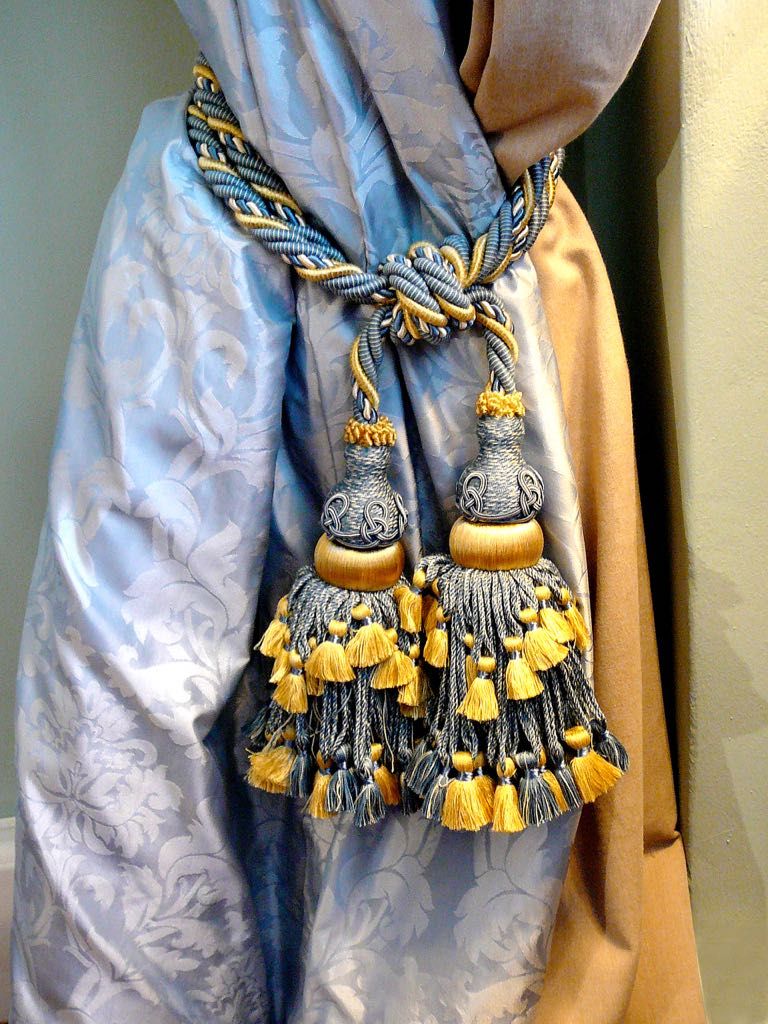 Un tissu bleu à motifs, orné d’une frange décorative.