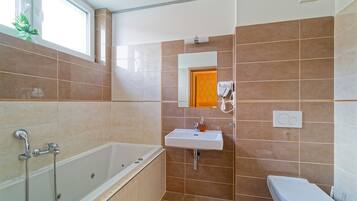 Comfort tweepersoonskamer | Badkamer | Een bubbelbad, een haardroger, handdoeken