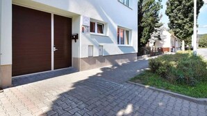 A building with a closed wooden door, a small window, and a paved entrance area. - Penzion Vanessa (Brno)